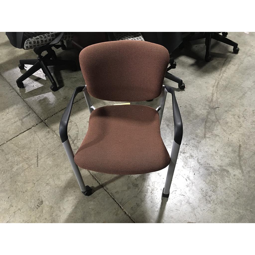 Orange and black patterned chair (w/ arms and wheels)