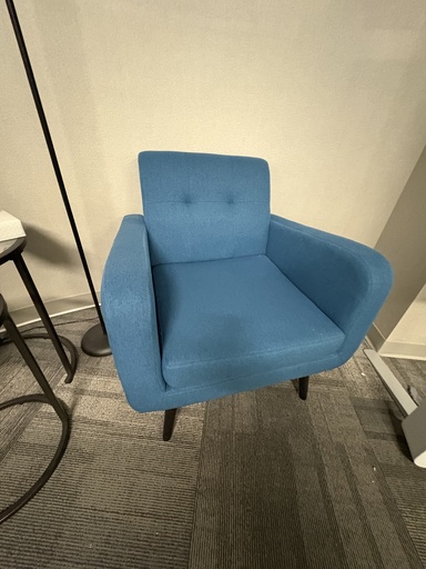 Blue fabric tufted arm chair with black feet 